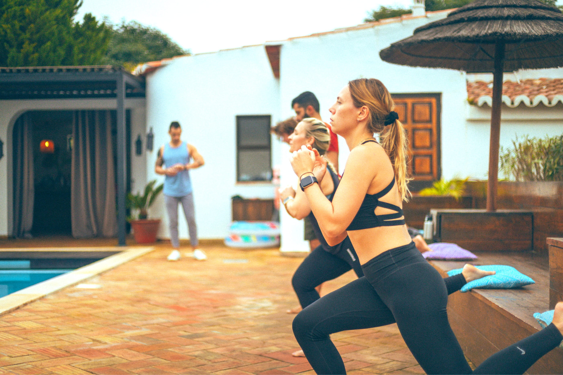 Residents training together in a lunging fitness session beside the pool